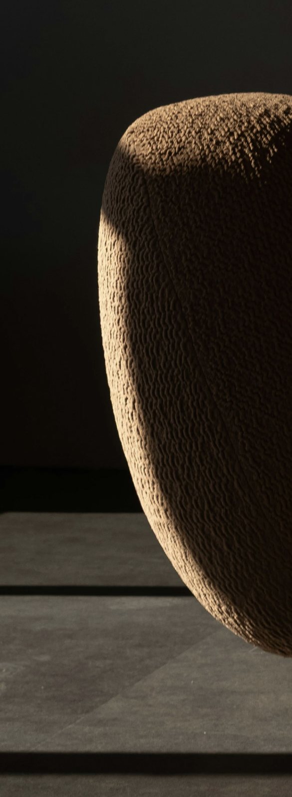 Close detail of a curved upholstered arm in textured bouclé